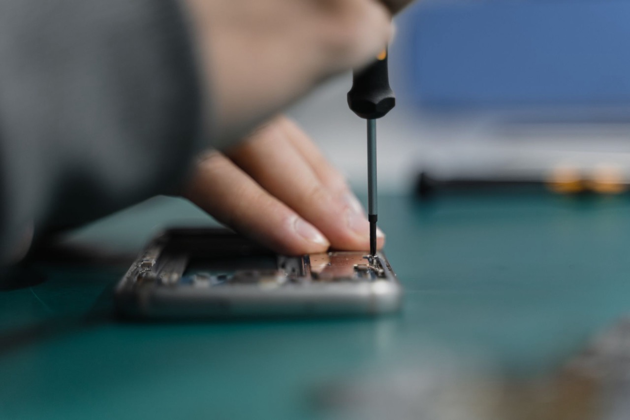 Tehnician reparând un telefon mobil în atelier